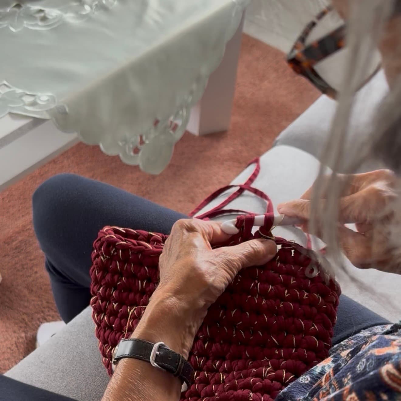 Mamie G crochète un sac à la main, maille après maille